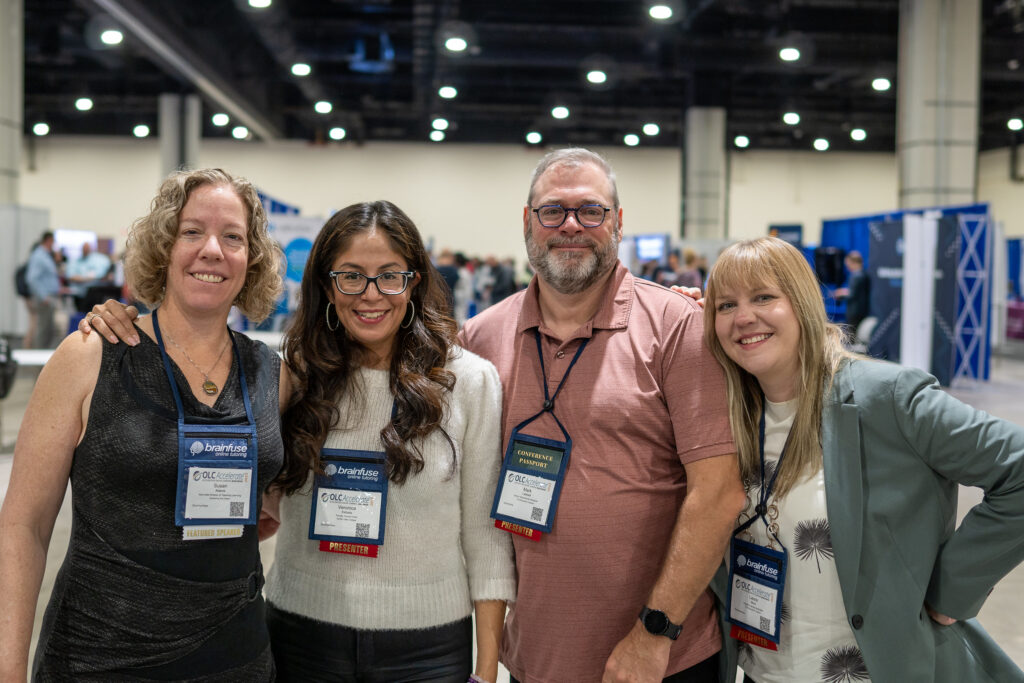 Four attendees at OLC Innovate 2023 smile for a photo