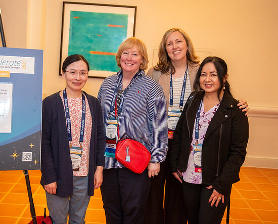 Photo of 4 women attending OLC accelerate posing for a photo in the conference foyer
