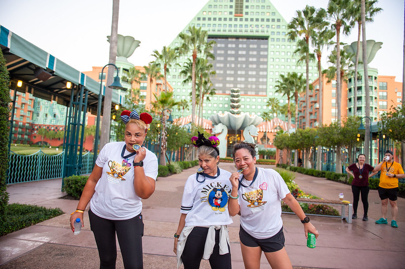 Photo of 3 runners from the OLC Accelerate 5K posing and pretending to bite their medals in celebration.
