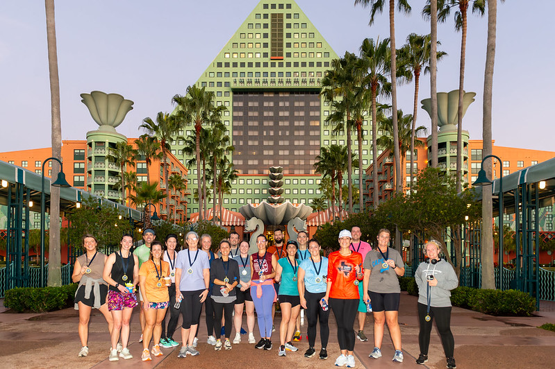 Wide photo of OLC Accelerate 5k participants posing together in front the Dolphin hotel exterior