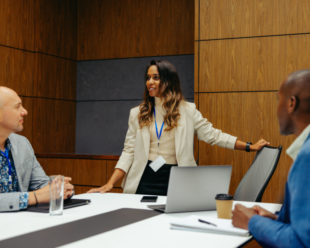 Photo of a woman leading a meeting in a large conference room.