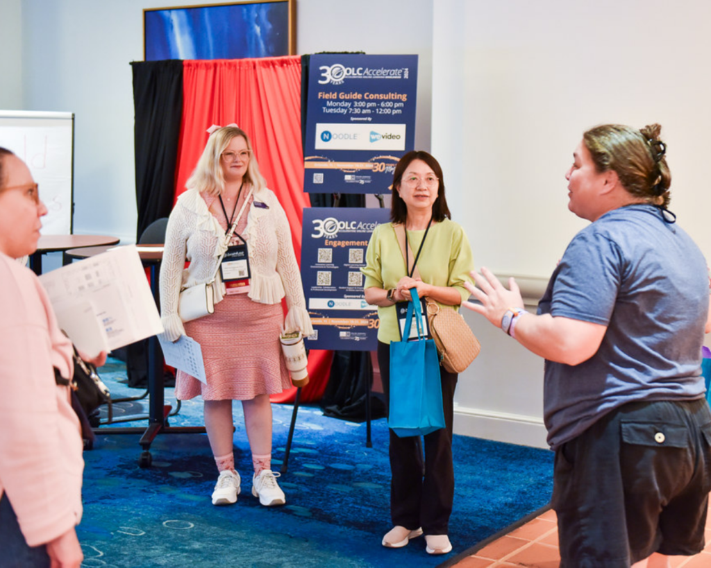 Photo of a field guide volunteer speaking to a group of conference attendees at OLC Accelerate